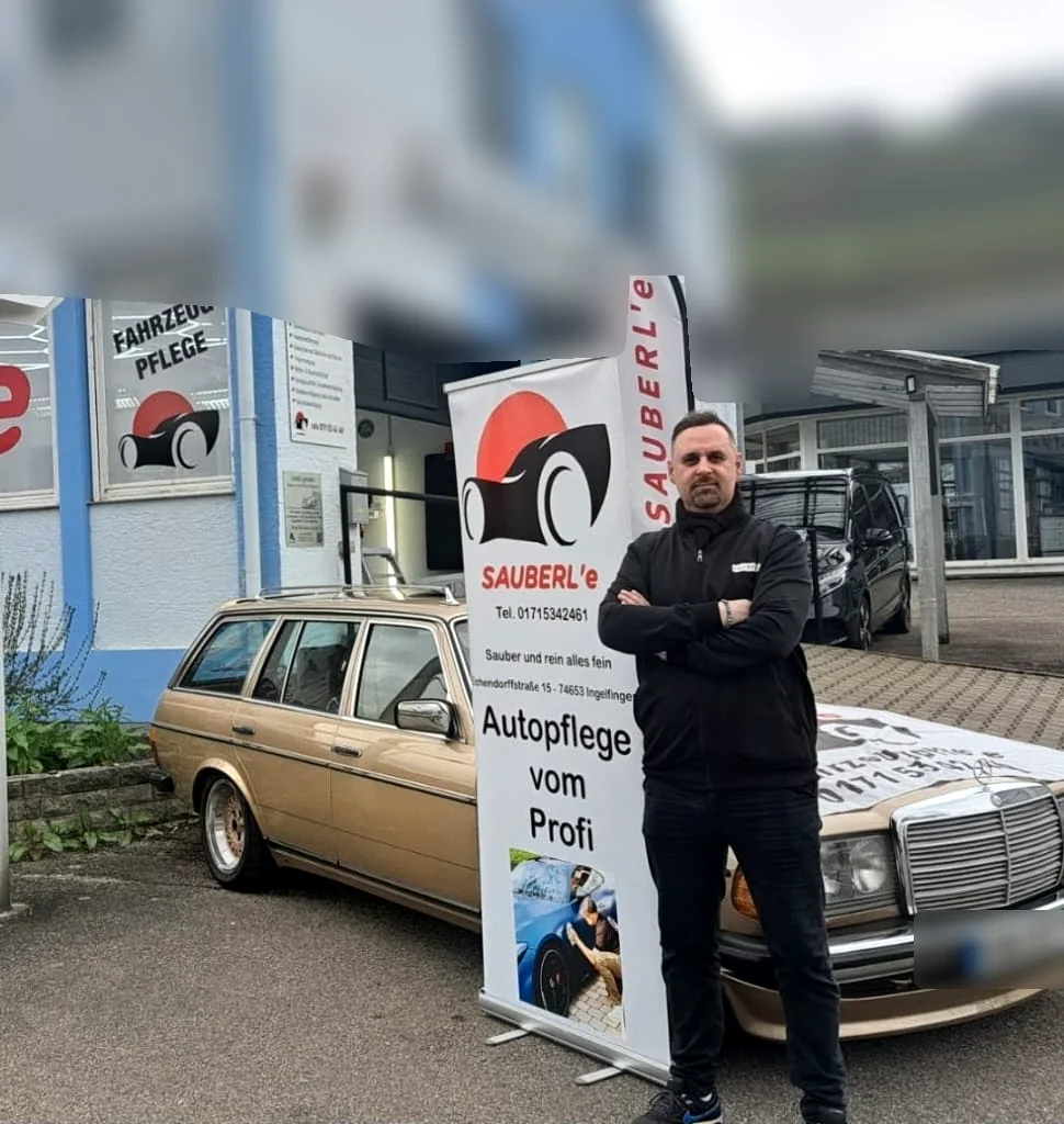 Inhaber Agim von Sauberle Fahrzeugpflege vor dem Aktionsbanner und einem aufbereiteten Mercedes Oldtimer